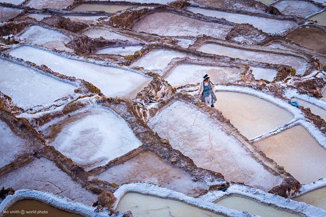 Leo Smith World Photo: Peru Photos and Prints - A lady stands on the edge of a salt pond in a steep valley, Salinas de Maras, Peru