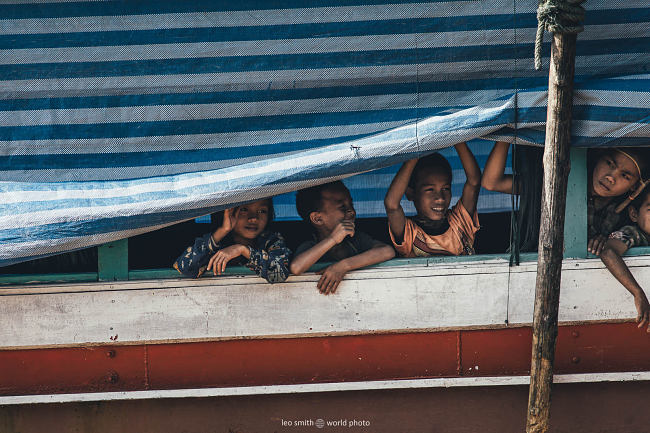 Leo Smith Photo Video | World Photo: Children peep their heads out from their boat on the Mekong River, Laos