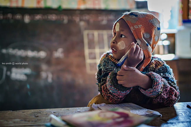 A young boy pauses to reflect during his school lesson, Shan State, Myanmar (Burma)