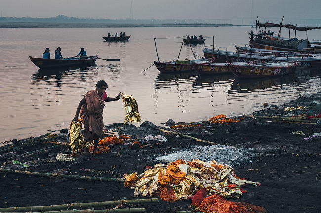 A woman picks up shrouds on one of the cremation ghats in Varanasi, India - Leo Smith Photo Video: travel, Documentary & Landscape Photography and Video