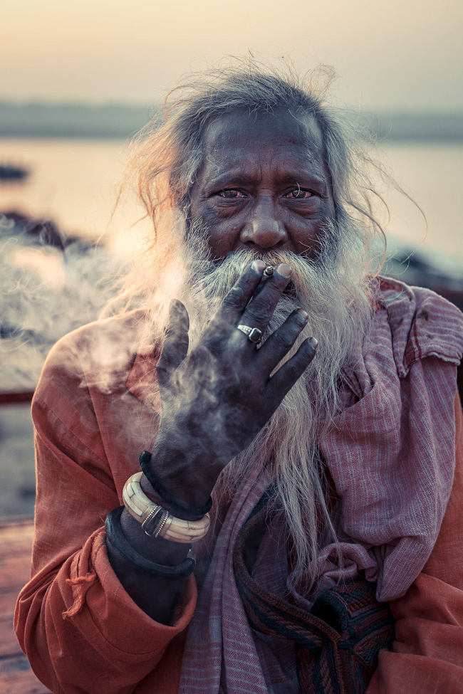 Leo Smith Photo Video: Leo Smith World Photo: Travel, Documentary & Landscape Photography and Video -- a man smokes a cigarette at sunrise on the edge of the River Ganges (Ganga), Varanasi, India