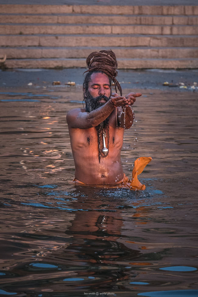 Leo Smith PhotoVideo | World Photo: A man performs his morning prayer rituals on the edge of the River Ganga (Ganges) at dawn, Varanasi, India