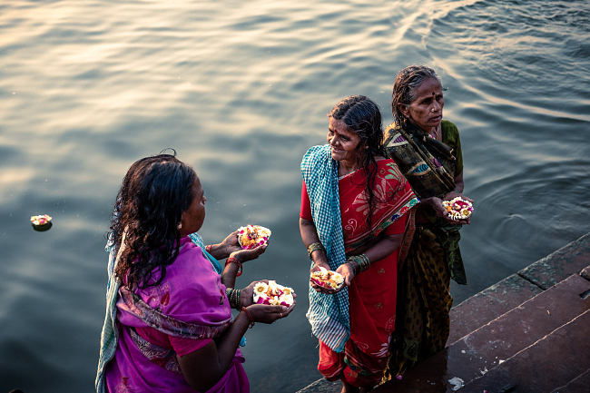 Woman hold prayer candles at sunrise on the Ganga (Ganges), Varanasi, India - Leo Smith Photo Video: travel, Documentary & Landscape Photography and Video