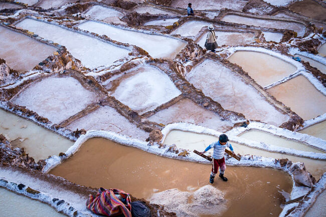 A boy works on the salt mines in Maras